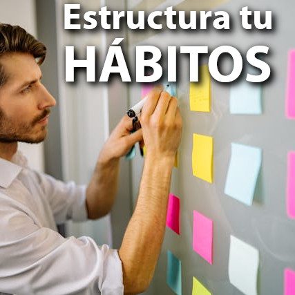 Hombre escribiendo en notas de colores bajo el texto "estructura tus hábitos".