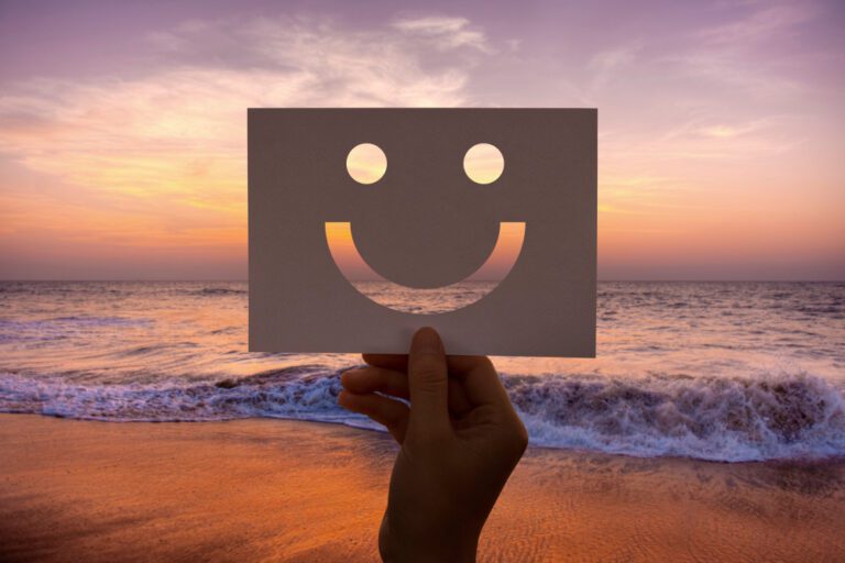 Emoji feliz sobre una playa